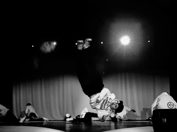 Danseur de breakdance à l'envers sur scène sous un projecteur